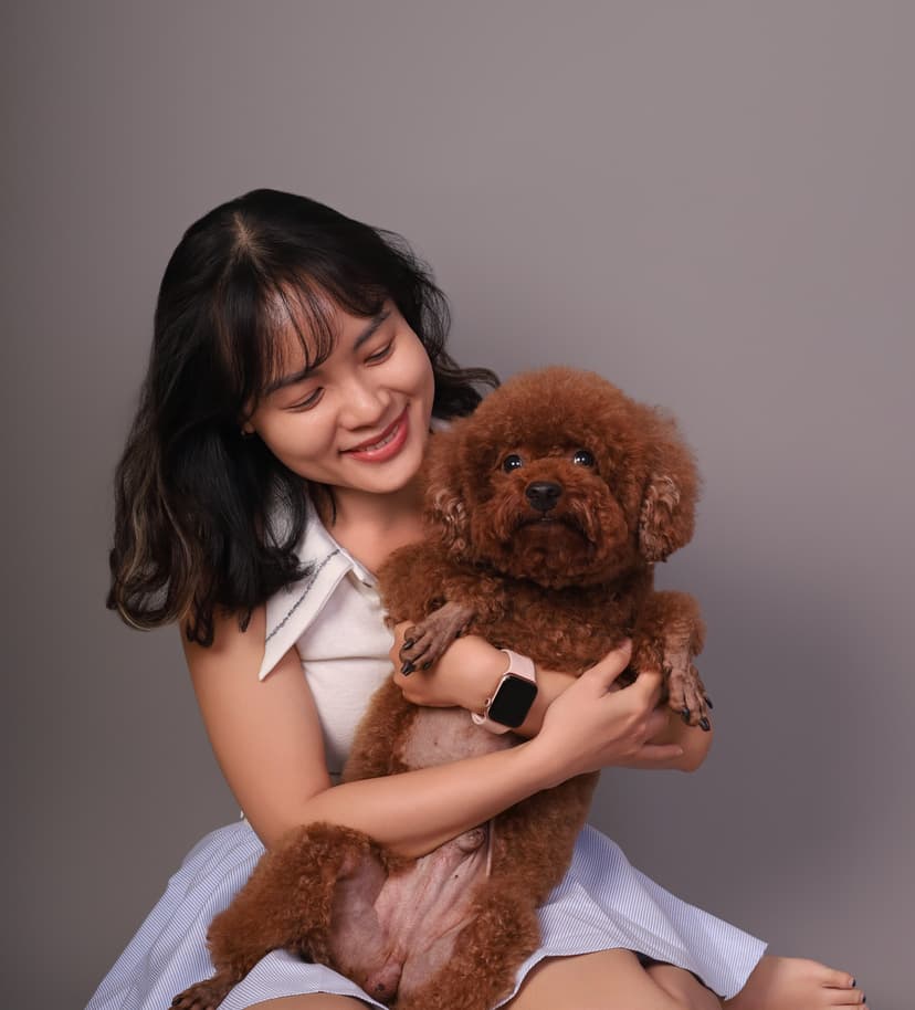 A girl is beaming as she hugs an adorable Poodle during a photo shoot at Petcial.